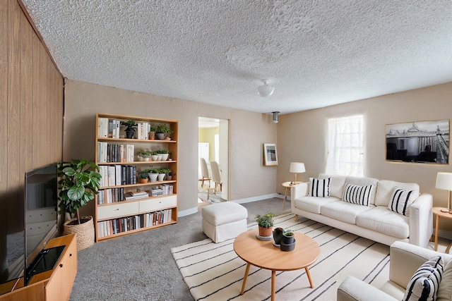 carpeted living room featuring a textured ceiling and wood walls