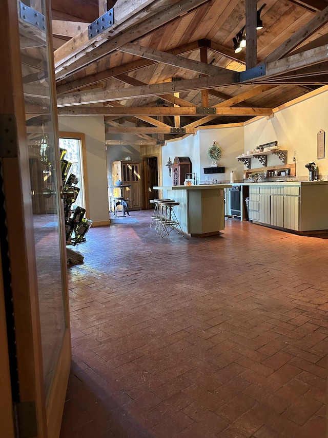 kitchen with wood ceiling, a breakfast bar, and vaulted ceiling with beams