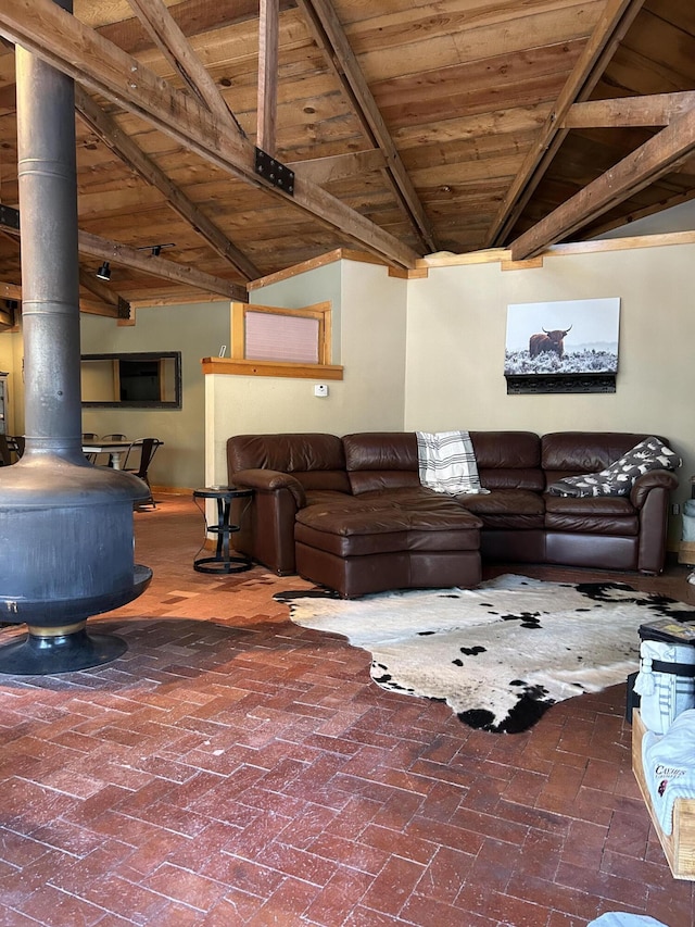 living room featuring wooden ceiling, lofted ceiling with beams, and a wood stove