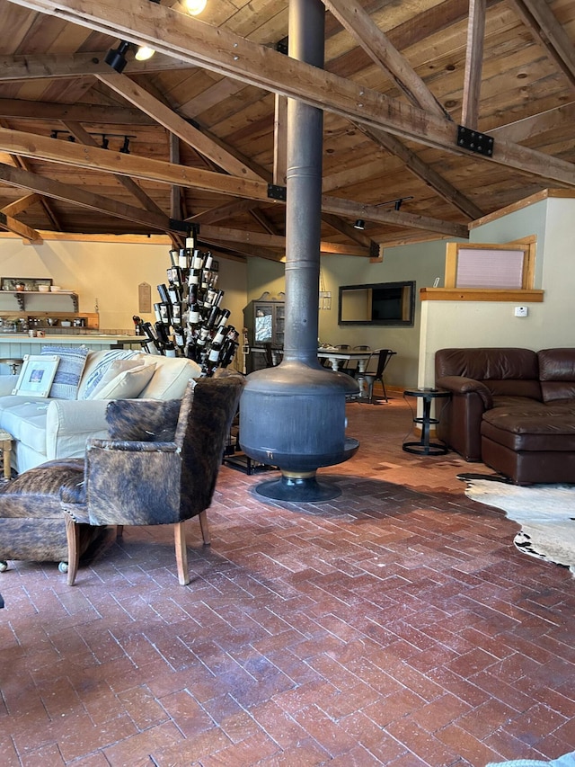 living room with wooden ceiling, lofted ceiling with beams, and a wood stove