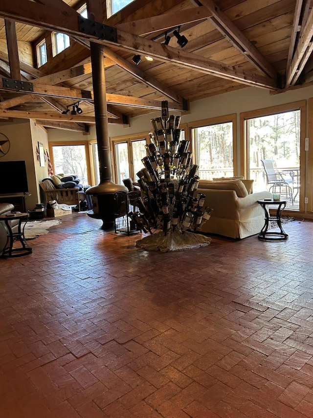 living room with a wood stove, wooden ceiling, and vaulted ceiling with beams