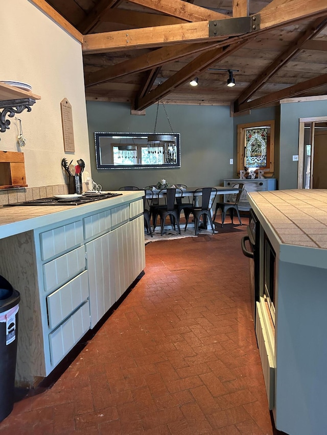 kitchen featuring wood ceiling, tile countertops, and vaulted ceiling with beams