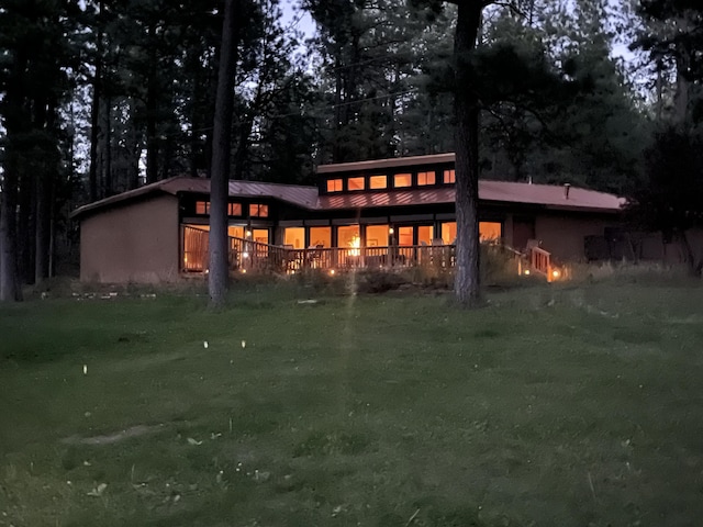 rear view of house featuring a yard