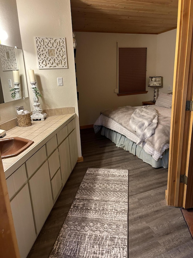 bedroom with sink, dark hardwood / wood-style flooring, and wooden ceiling