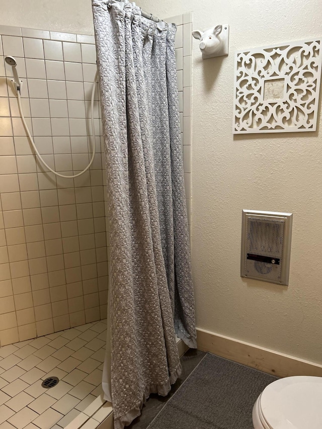 bathroom with curtained shower, tile patterned floors, and toilet