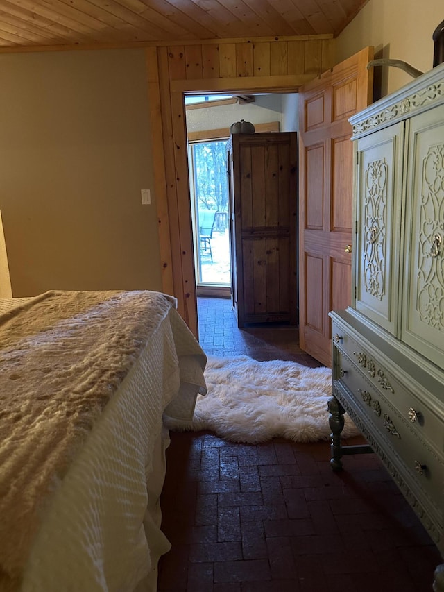 bedroom featuring access to outside and wooden walls