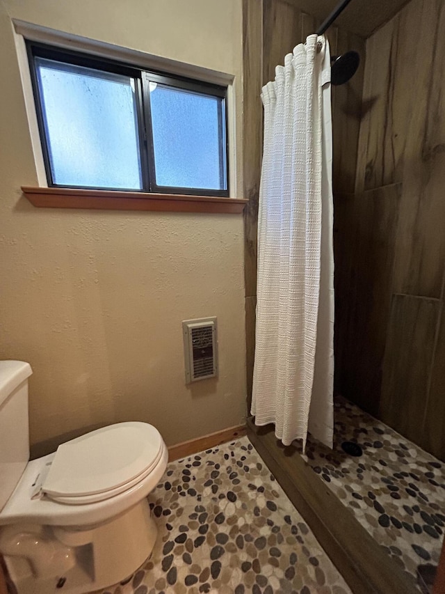 bathroom with toilet, a wealth of natural light, and walk in shower