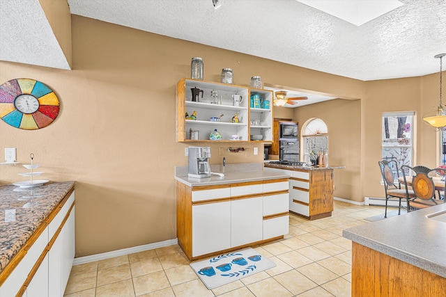 kitchen with white cabinetry, hanging light fixtures, black microwave, and a baseboard heating unit