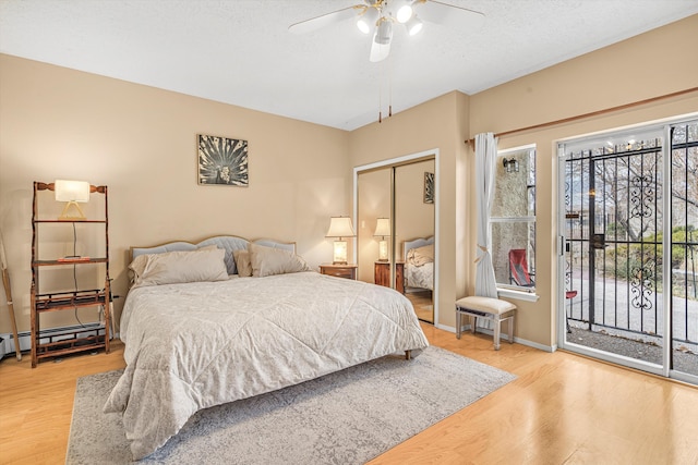 bedroom with ceiling fan, access to exterior, wood-type flooring, a textured ceiling, and a closet