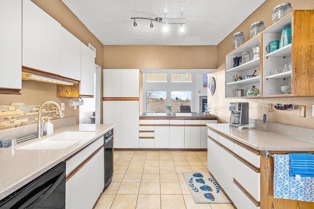 kitchen featuring sink, light tile patterned floors, black dishwasher, white cabinets, and backsplash