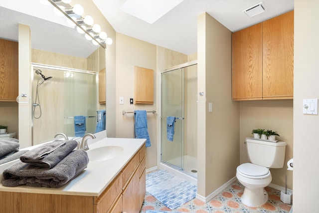 bathroom with walk in shower, tile patterned floors, toilet, a skylight, and vanity