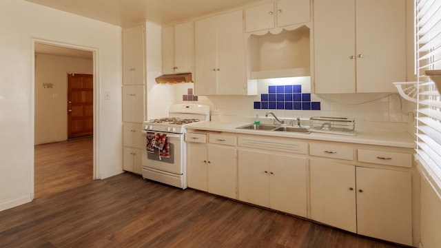 kitchen featuring white cabinets, white gas range, sink, and tasteful backsplash