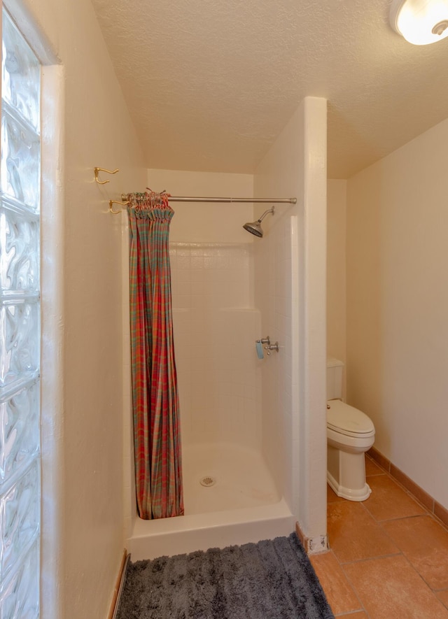 bathroom featuring tile patterned floors, curtained shower, a textured ceiling, and toilet