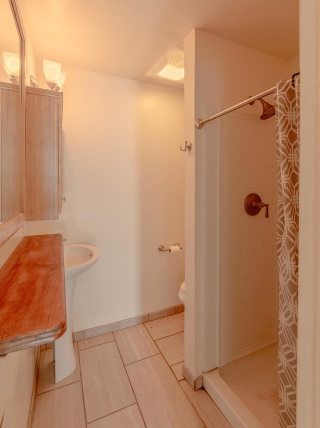 bathroom featuring tile patterned floors, a shower with curtain, and toilet