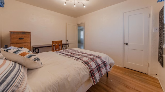 bedroom featuring a chandelier and hardwood / wood-style flooring