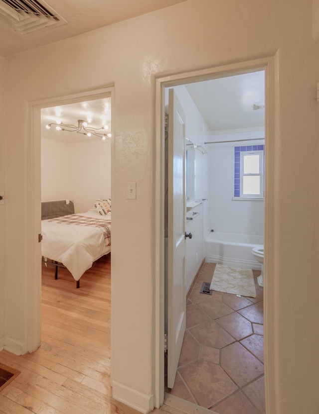 bathroom with wood-type flooring and tiled shower / bath