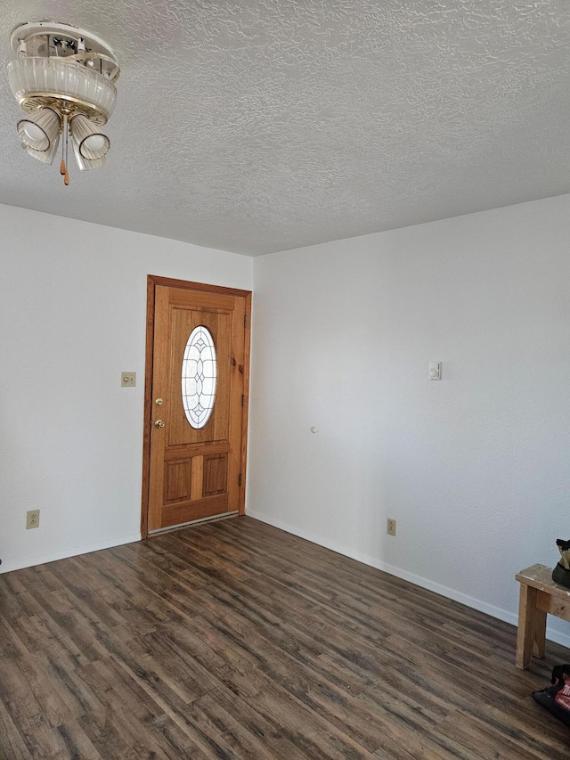 foyer entrance featuring a textured ceiling and dark wood-type flooring