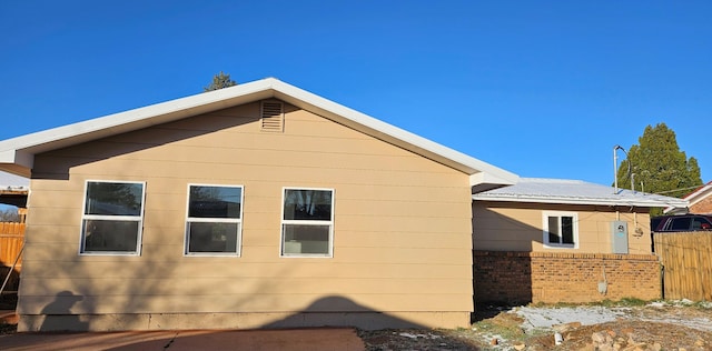 view of home's exterior featuring brick siding and fence