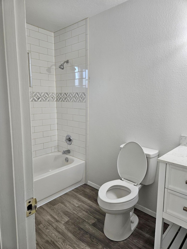 full bath with toilet, baseboards, wood finished floors, and vanity