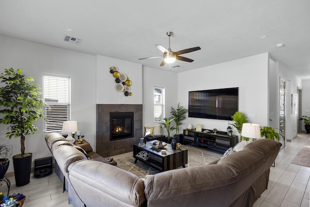 living room featuring a fireplace and ceiling fan