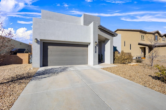 view of front facade with a garage, driveway, and stucco siding