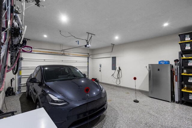 garage featuring a garage door opener, stainless steel refrigerator, and electric panel