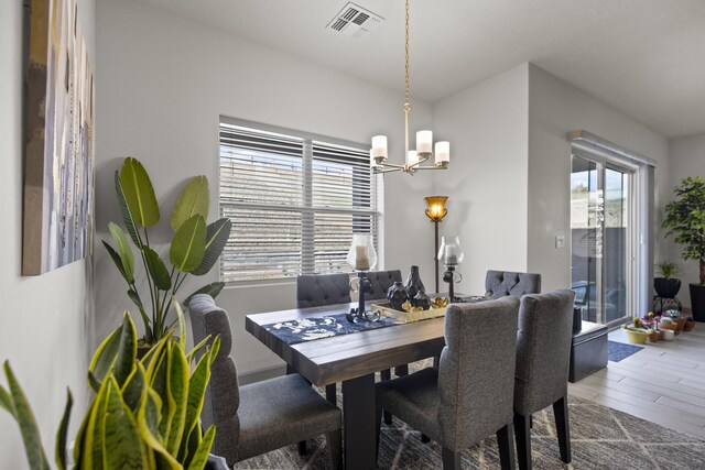 dining area with a notable chandelier and hardwood / wood-style floors