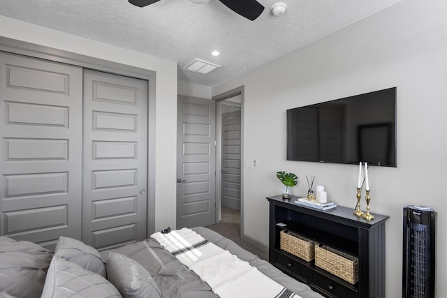 carpeted bedroom featuring a closet, visible vents, a textured ceiling, and baseboards