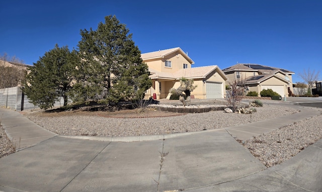 view of front of property with a garage and solar panels