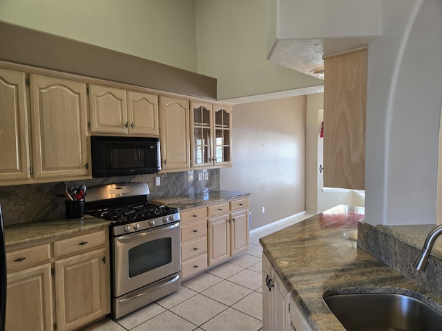 kitchen featuring sink, light brown cabinets, light tile patterned floors, and gas stove