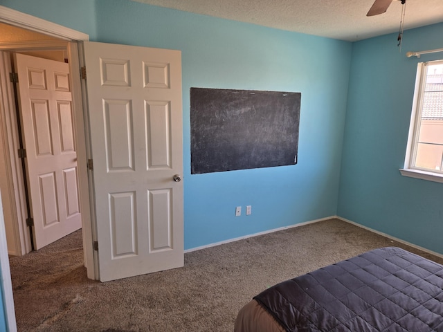 unfurnished bedroom with ceiling fan, carpet flooring, and a textured ceiling