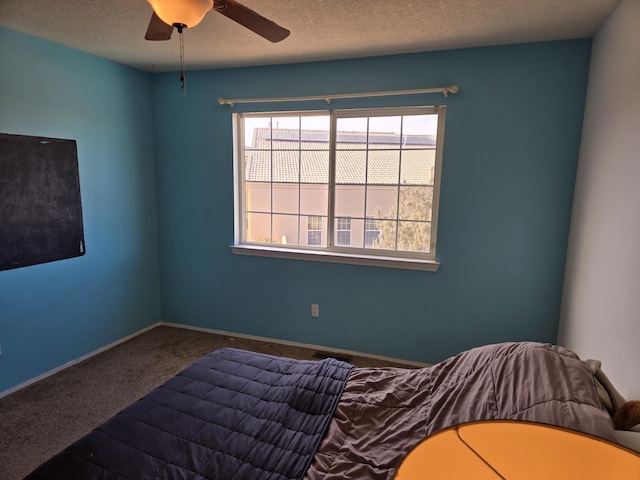 unfurnished bedroom with ceiling fan, carpet, and a textured ceiling