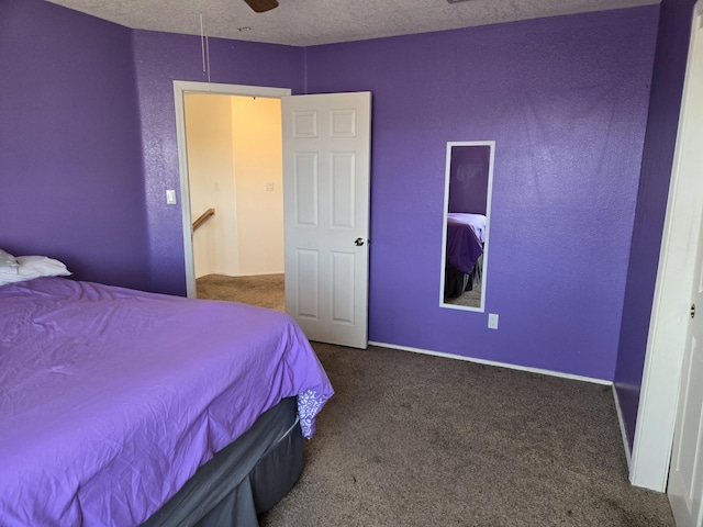 carpeted bedroom featuring ceiling fan and a textured ceiling