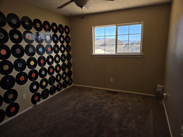 carpeted empty room featuring a textured ceiling and ceiling fan