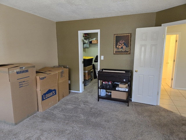 miscellaneous room with light colored carpet and a textured ceiling