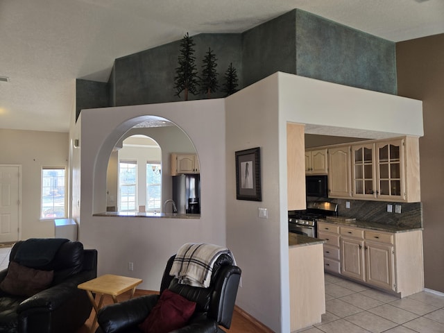 interior space featuring a towering ceiling and light tile patterned floors