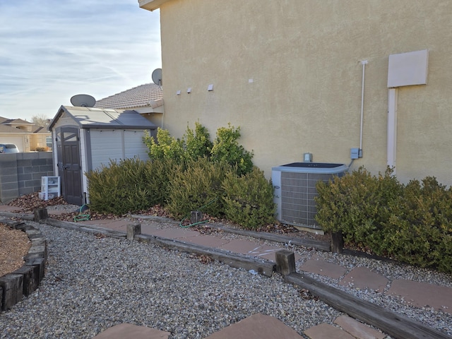 view of side of property featuring cooling unit and a shed