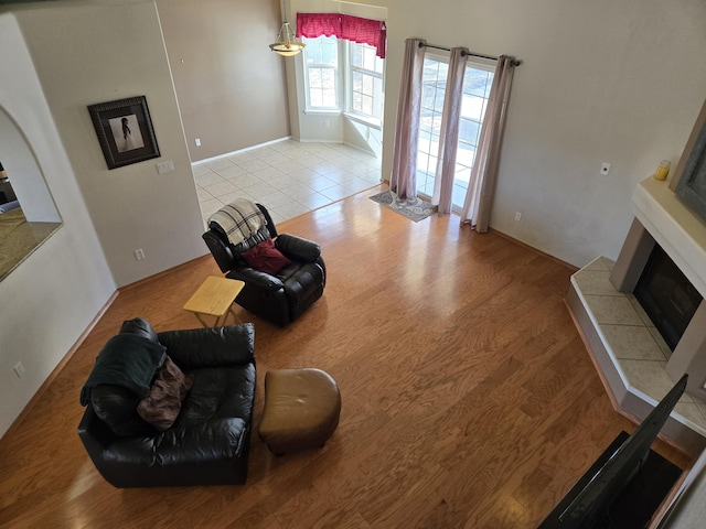 living room featuring a tile fireplace and light wood-type flooring