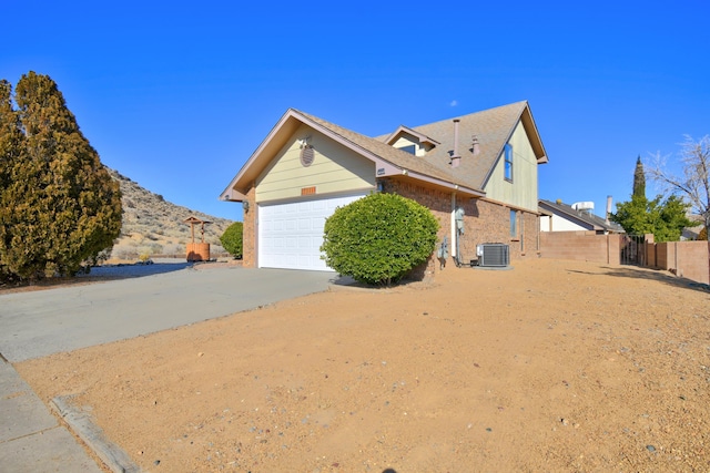 view of property exterior featuring central AC unit and a garage