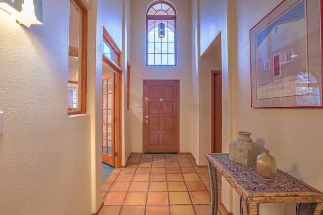 entryway featuring a high ceiling and light tile patterned floors