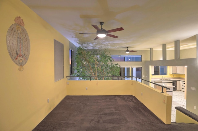 unfurnished room with ceiling fan, light colored carpet, and sink