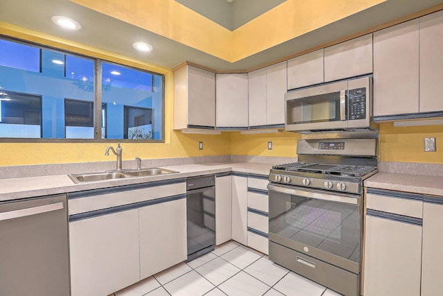 kitchen with white cabinets, appliances with stainless steel finishes, sink, and light tile patterned flooring