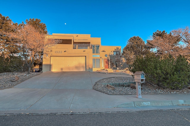 southwest-style home featuring a garage and a balcony