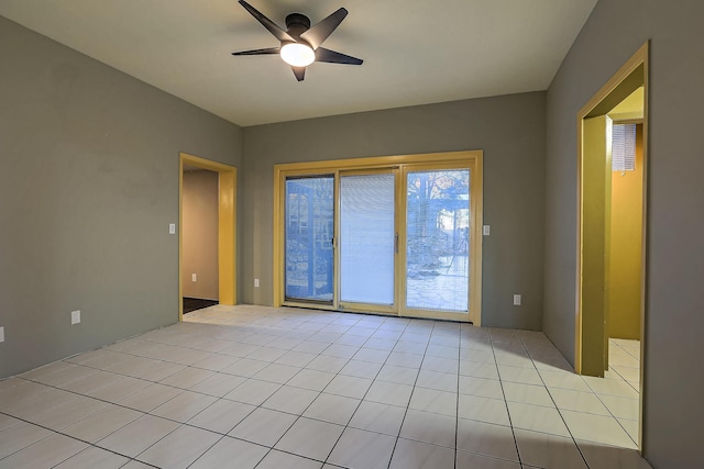 tiled spare room with ceiling fan