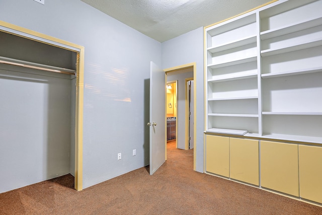 unfurnished bedroom with a textured ceiling and light colored carpet