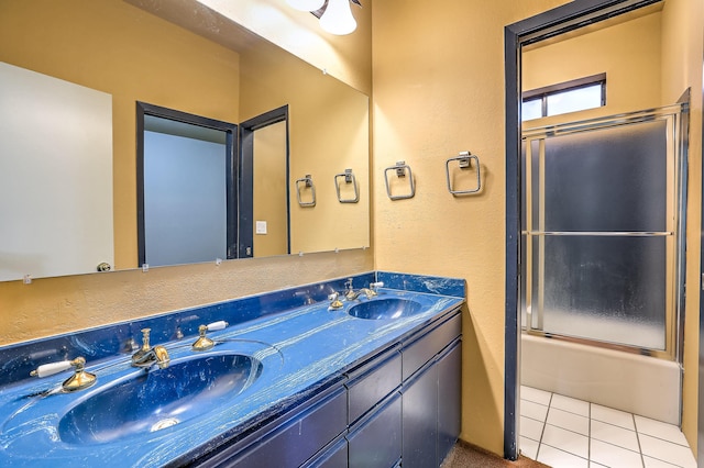 bathroom with tile patterned floors, shower / bath combination with glass door, and vanity