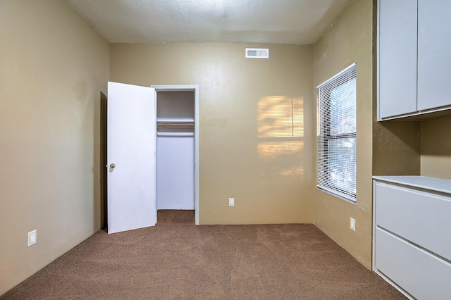 unfurnished bedroom featuring a closet and light colored carpet