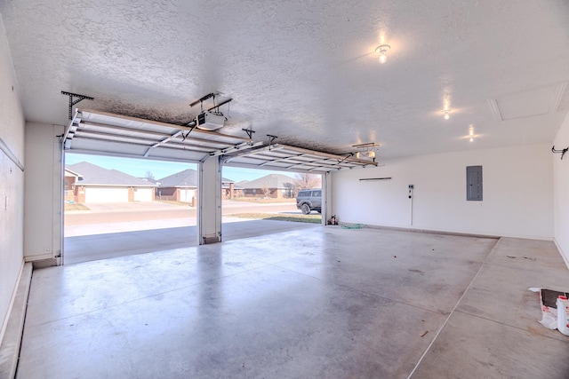 garage with a garage door opener and electric panel