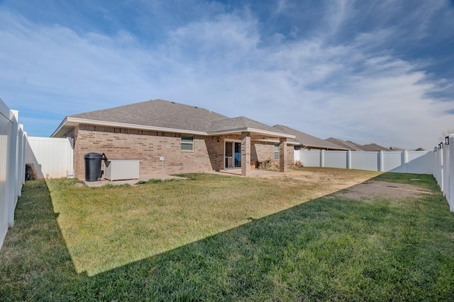 back of house featuring a yard and a patio area