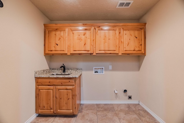 laundry room with hookup for a gas dryer, washer hookup, light tile patterned floors, sink, and cabinets